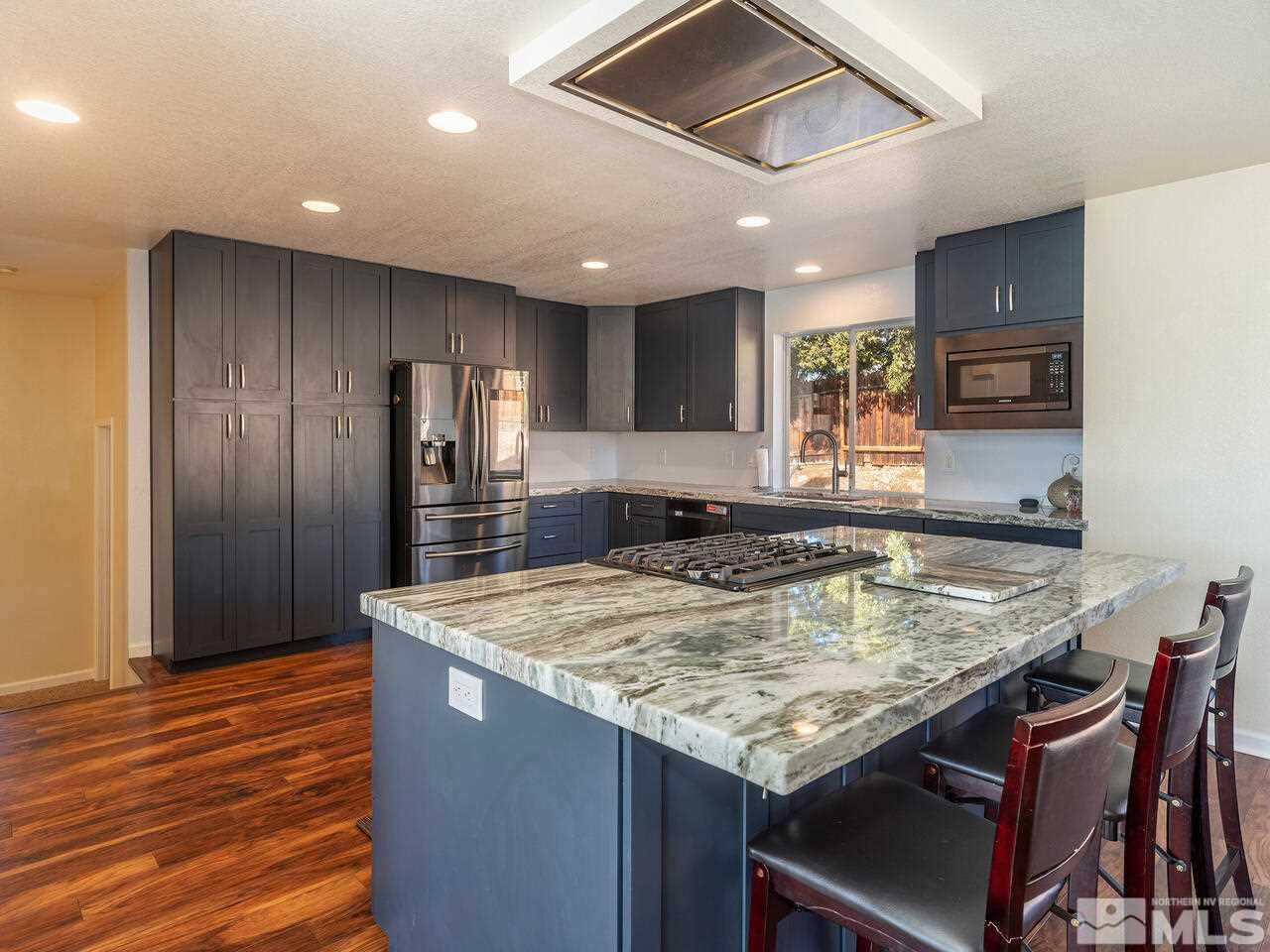 821 University Ridge Drive Reno, NV 89512 - Photo 13 of 28 a kitchen with center island table and chairs