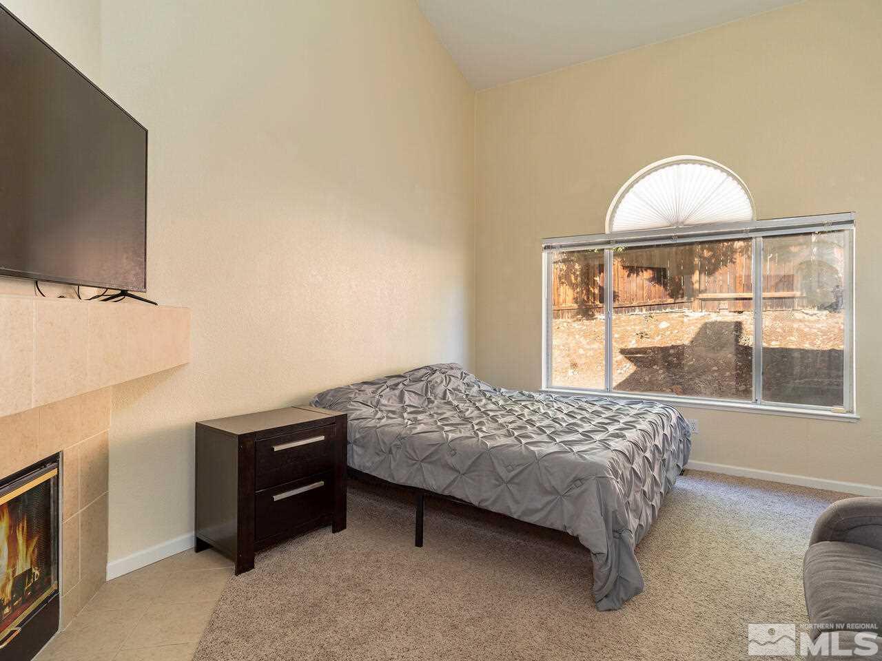821 University Ridge Drive Reno, NV 89512 - Photo 15 of 28 a bedroom with a bed dresser and a flat tv screen