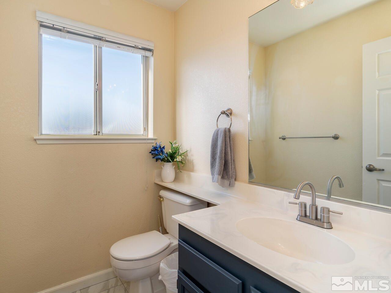 821 University Ridge Drive Reno, NV 89512 - Photo 16 of 28 a bathroom with a sink a toilet and mirror