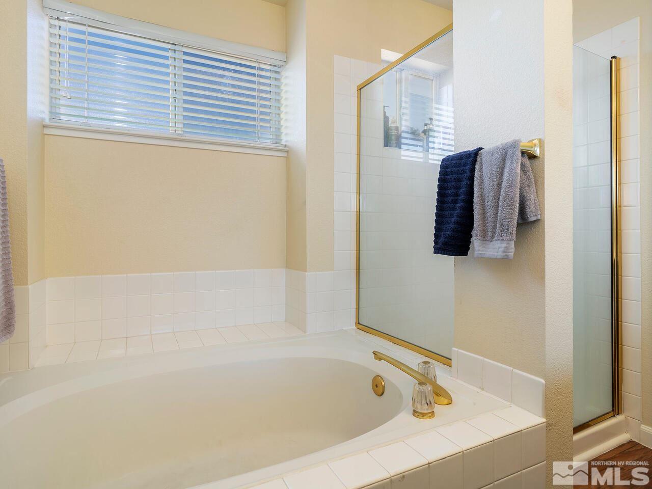821 University Ridge Drive Reno, NV 89512 - Photo 20 of 28 a bathroom with a bathtub and a shower