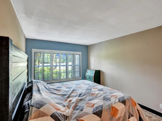 a bedroom with a bed and a large window