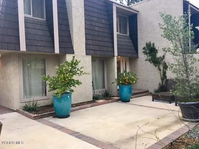 a view of a house with potted plants