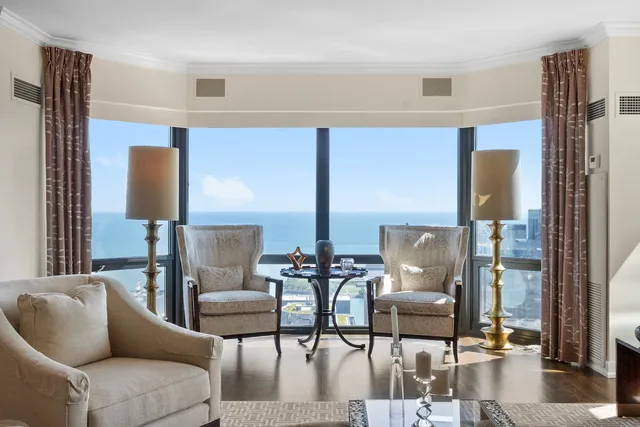 a living room with couches chairs and a coffee table with wooden floor