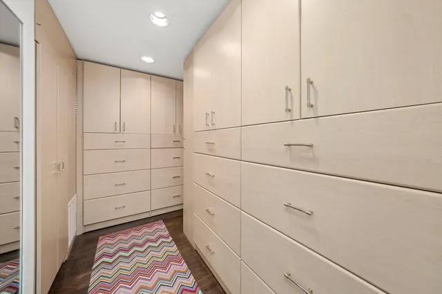 a living room with furniture a floor to ceiling window and wooden floor