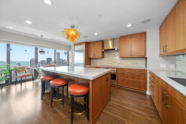a kitchen with stainless steel appliances granite countertop a table chairs sink and cabinets