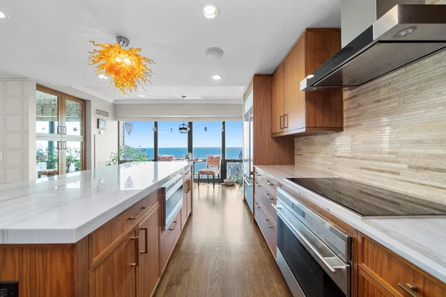 a kitchen with stainless steel appliances granite countertop a sink a stove and a wooden floors