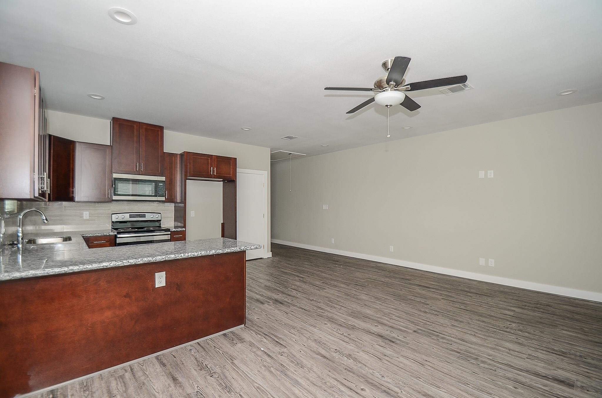 3249 Dixie Drive, Unit B Houston, TX 77021 - Photo 6 of 8 a kitchen with granite countertop a sink cabinets and wooden floor