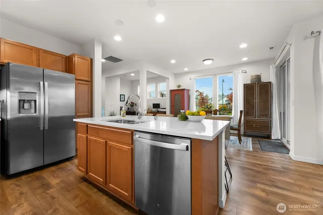 a kitchen with stainless steel appliances granite countertop a refrigerator a sink and a stove