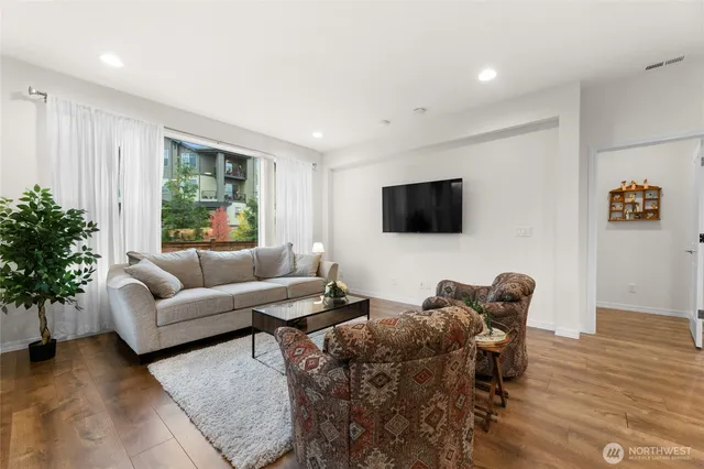 a living room with furniture a flat screen tv and a potted plant