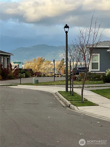 a street sign on a sidewalk next to a road