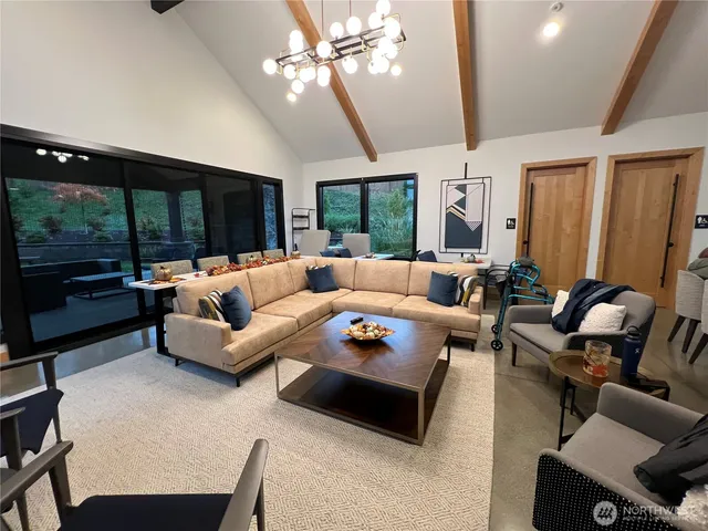 a living room with furniture a flat screen tv and a large window