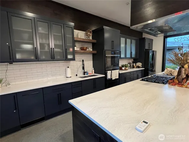 a kitchen with stainless steel appliances a sink dishwasher stove refrigerator and cabinets