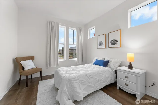 a bedroom with a bed and a lamp on dresser