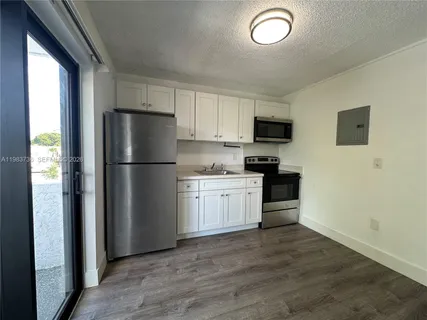 a kitchen with a refrigerator and a stove top oven