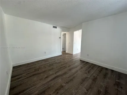 a view of an empty room and wooden floor
