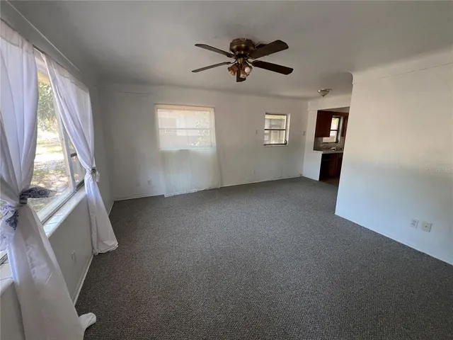 a view of a livingroom with a ceiling fan and window