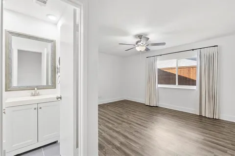 a view of an empty room with a bathroom sink and a window