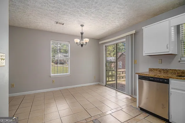 a view of an empty room with window and cabinet