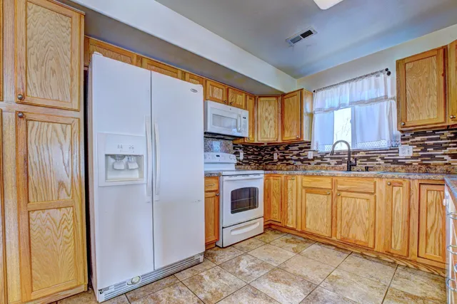 a kitchen with stainless steel appliances granite countertop a refrigerator and a stove top oven