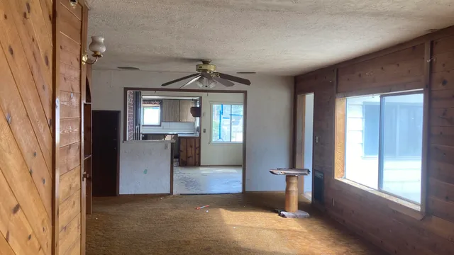 an empty room that has a window and kitchen view
