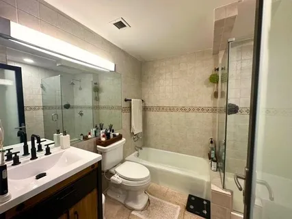 a bathroom with a sink a toilet a mirror and shower