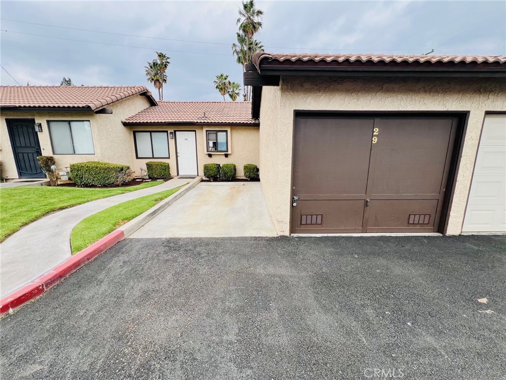 9505 Arlington Avenue, Unit 29 Riverside, CA 92503 - Photo 2 of 21 a view of a house with a yard and garage