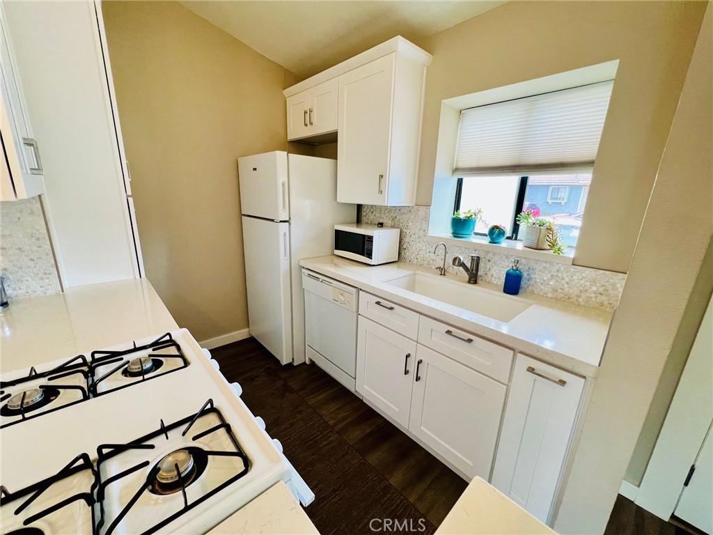 9505 Arlington Avenue, Unit 29 Riverside, CA 92503 - Photo 9 of 21 a kitchen with sink a refrigerator and a stove top oven