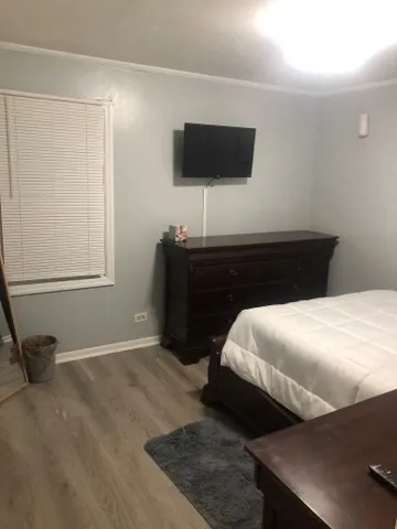 a bedroom with a bed and a flat tv screen on a dresser