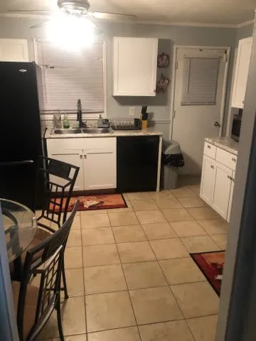 a kitchen with a sink a refrigerator and chairs
