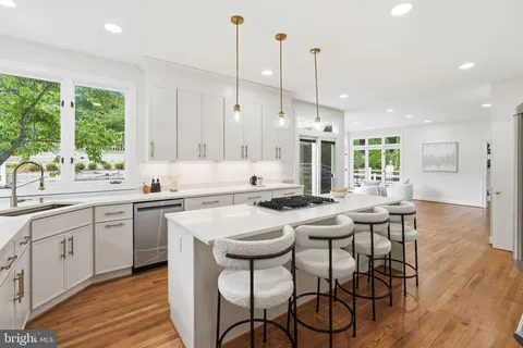 a kitchen with stainless steel appliances granite countertop white cabinets and wooden floor
