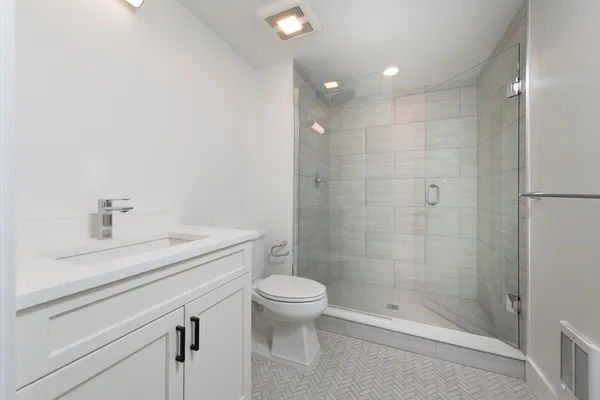 a bathroom with a sink a toilet and shower