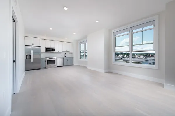 a view of a kitchen with refrigerator and window