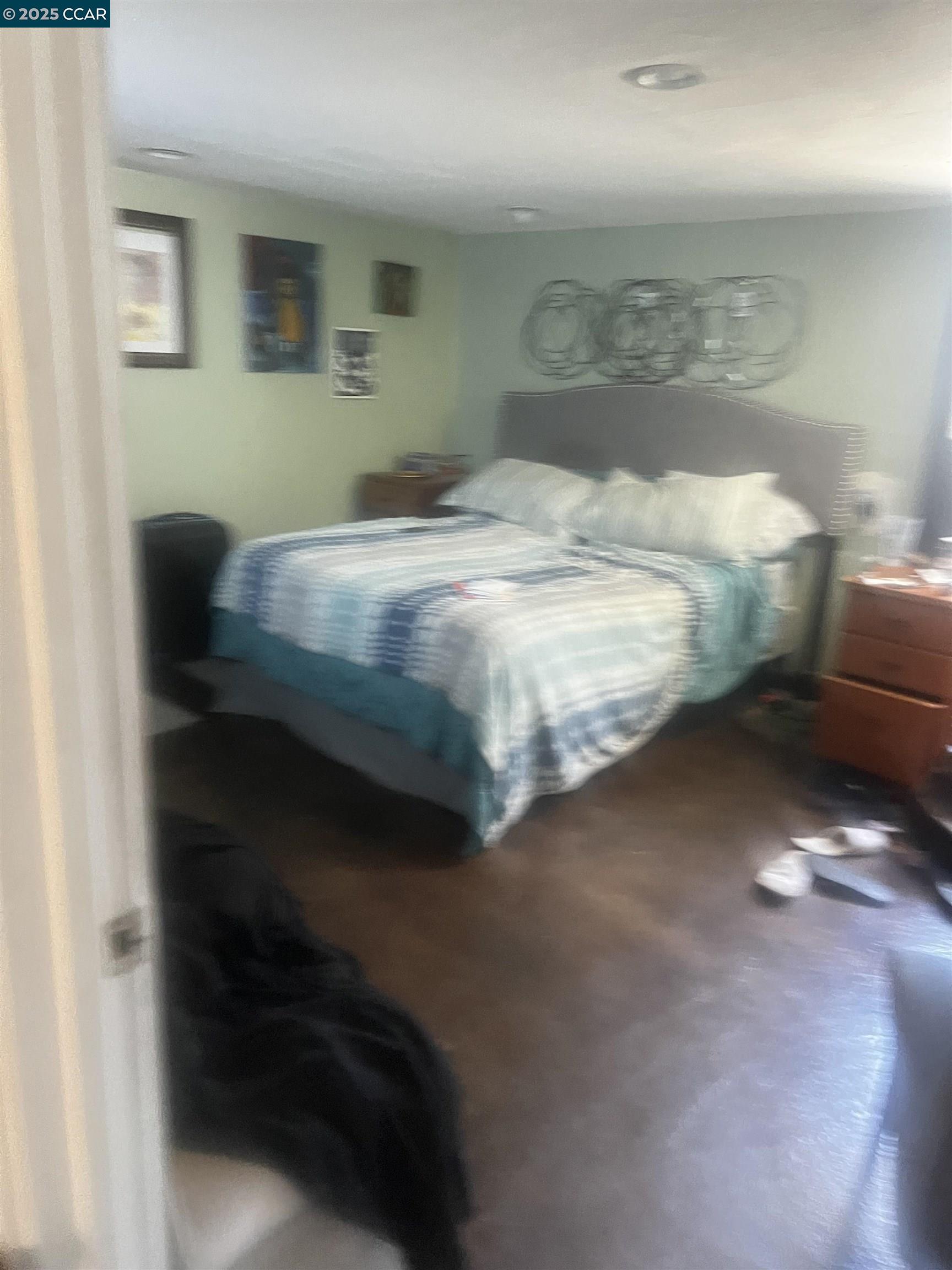 1161 64th Street Oakland, CA 94608 - Photo 22 of 34 a bedroom with a bed and a mirror