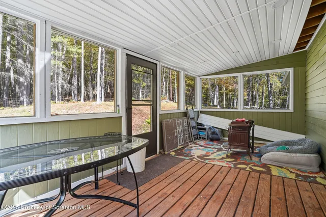 a view of a patio with table and chairs and floor to ceiling window