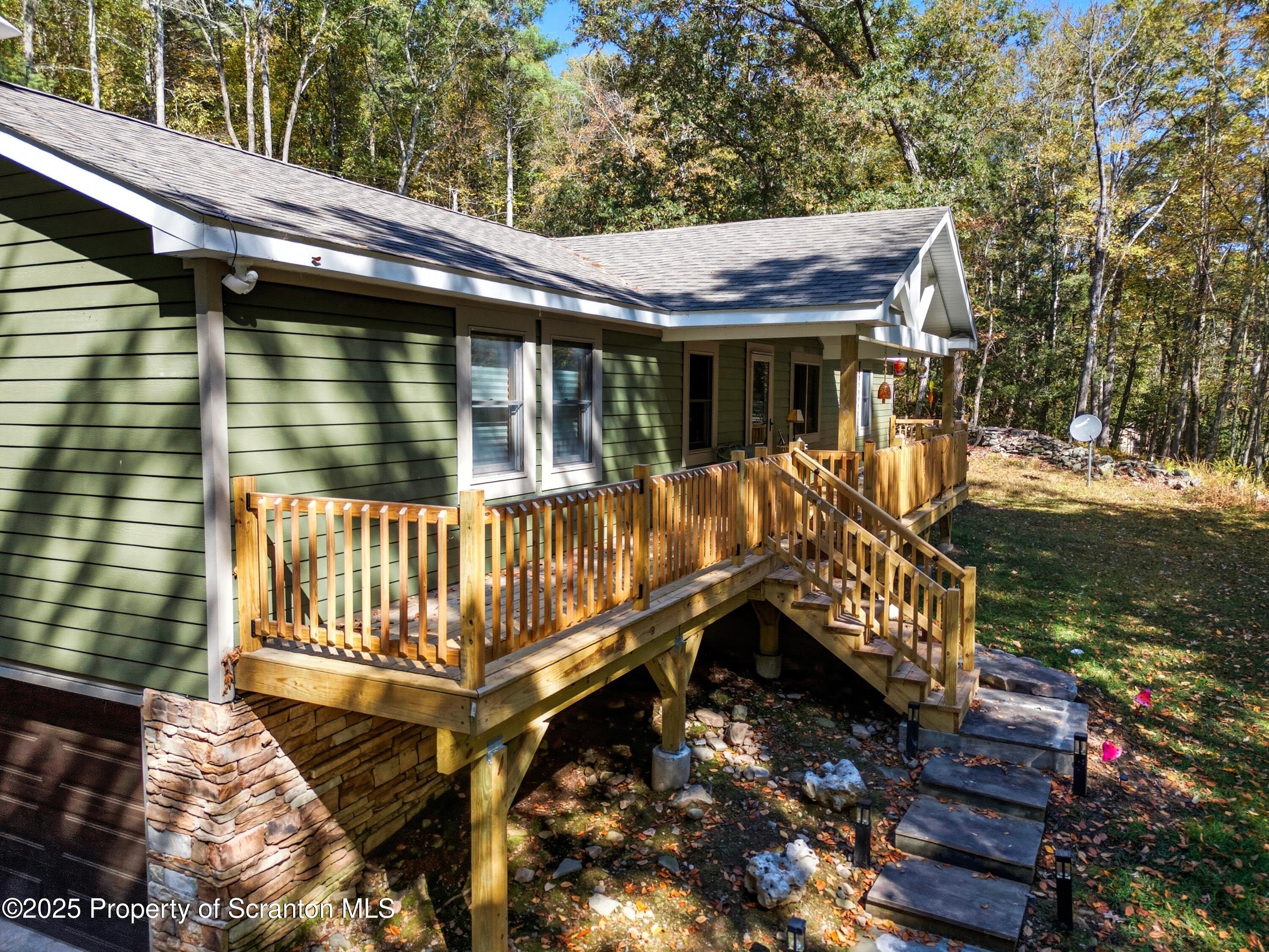 452 Engvaldsen Road Hawley, PA 18428 - Photo 40 of 42 a view of a wooden deck with chairs and a yard