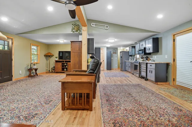 a large kitchen with stainless steel appliances granite countertop a stove a sink dishwasher and a refrigerator with wooden floor