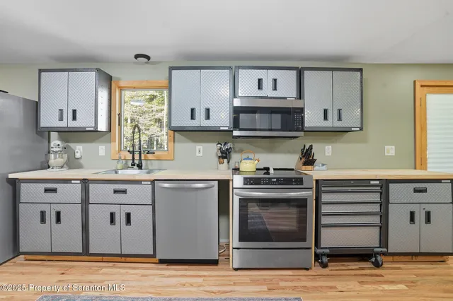 a kitchen with stainless steel appliances granite countertop a refrigerator sink and stove