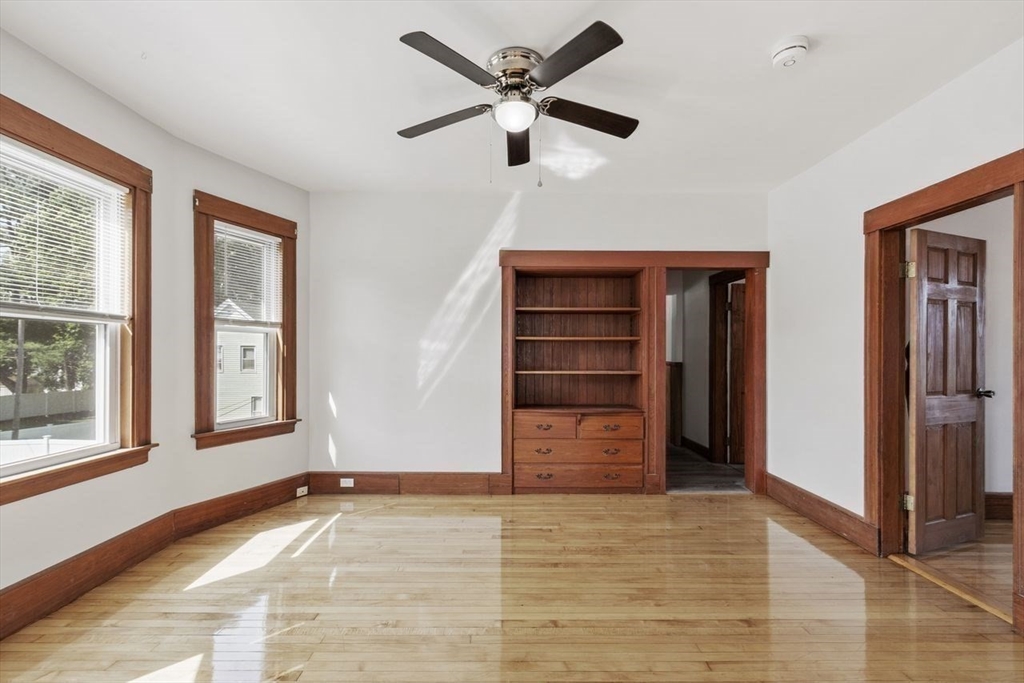a view of an empty room with a window and a ceiling fan