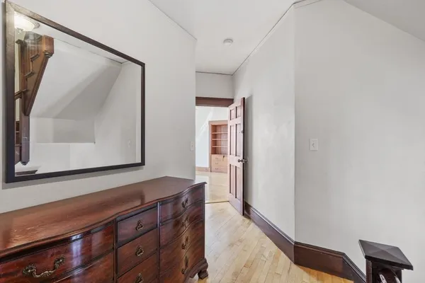 a view of room with wooden floor and hallway