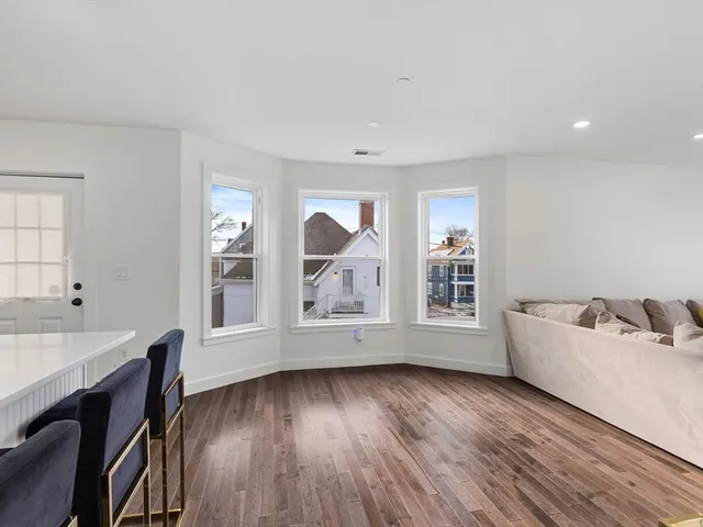 a view of workspace with wooden floor and kitchen view