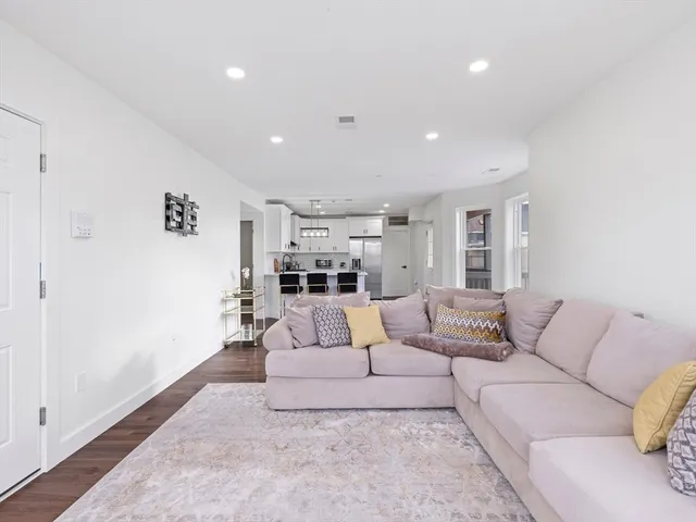 a living room with furniture and view of kitchen