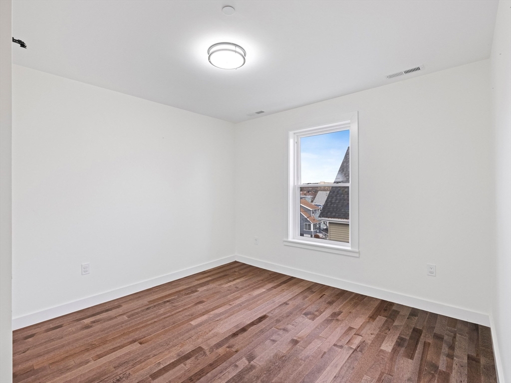11 Seymour Avenue, Unit 3 Lynn, MA 01902 - Photo 30 of 38 an empty room with wooden floor and windows
