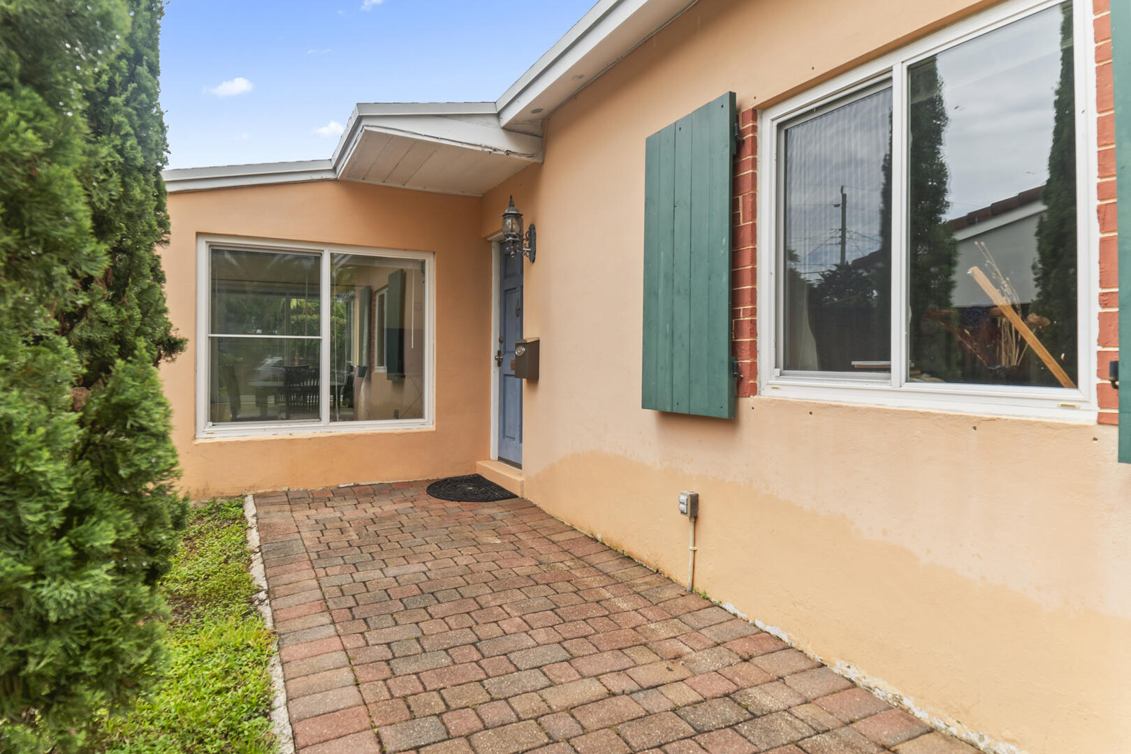 906 Northeast 5th Street Hallandale Beach, FL 33009 - Photo 3 of 35 a front view of a house with a blue gate