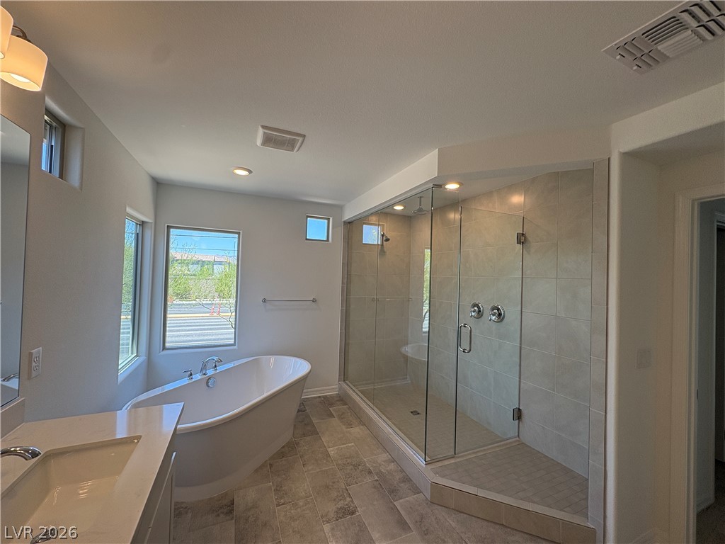8677 South Indigo Springs Road Las Vegas, NV 89139 - Photo 8 of 9 Indulge in a spa-like retreat with this well-lit primary bathroom's spacious shower and free-standing soaking tub.