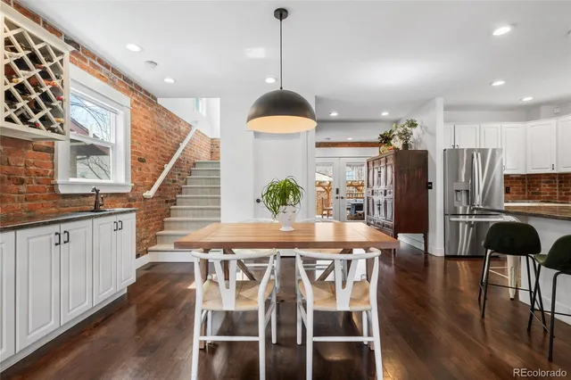 a dining room with stainless steel appliances kitchen island granite countertop a dining table chairs and granite counter tops