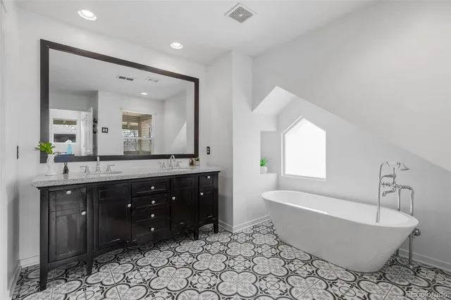 a spacious bathroom with a bathtub sink and mirror