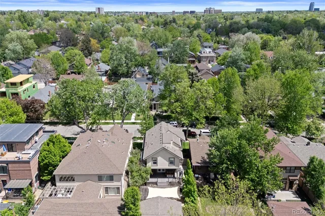 an aerial view of a city with lots of residential buildings and mountain view in back