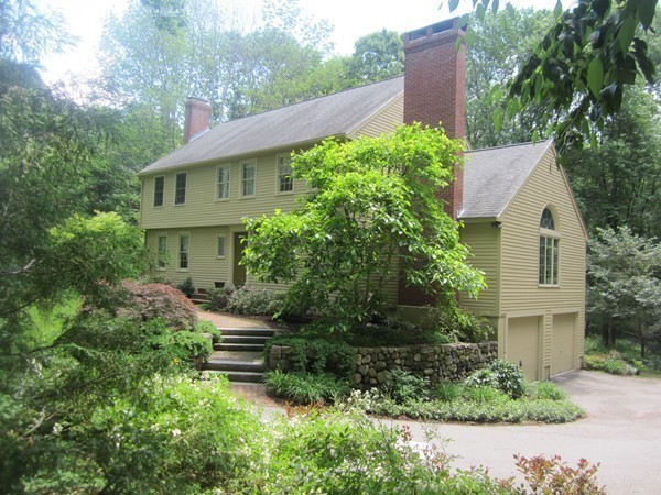 a front view of a house with a yard and trees