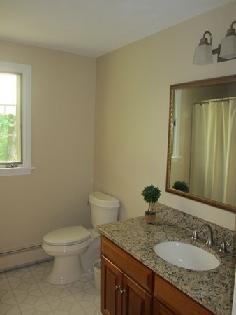 286 Sargent Road Boxborough, MA 01719 - Photo 21 of 29 a bathroom with a granite countertop toilet a sink and mirror
