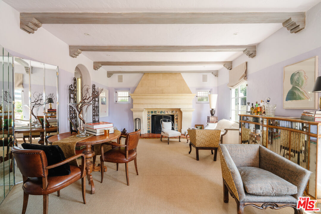 8430 Cresthill Road Los Angeles, CA 90069 - Photo 14 of 36 a living room with furniture a fireplace and a dining table with wooden floor
